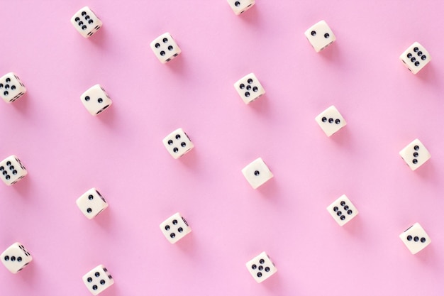 Gaming dice pattern on pink background in flat lay style Top view Closeup