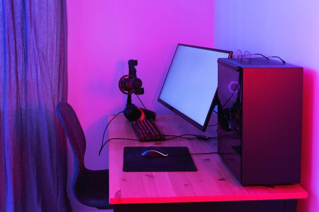 Gaming-pc en ultrabrede monitor in neonlicht