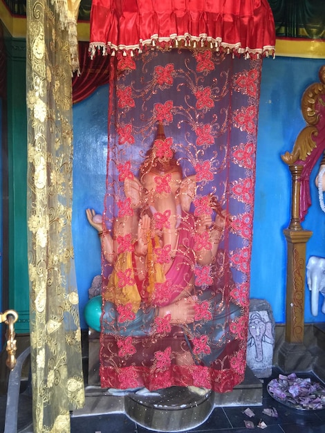 Photo ganesha sculpture seen through curtain