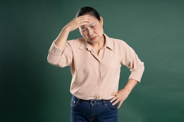 사진 파란색 배경에 포즈를 취하는 강강 중년 아시아 여성 초상화