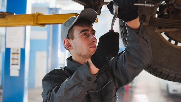 Garage autoservice een monteur onder de auto controleert het wiel