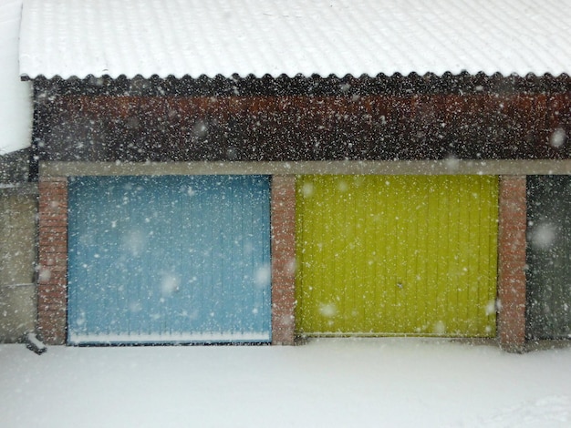 Дверь гаража и снег перед ней покрыты снегом