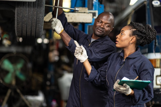 Команда гаражных механиков, работающих в автосервисе, чернокожие африканские люди, профессиональные работники вместе