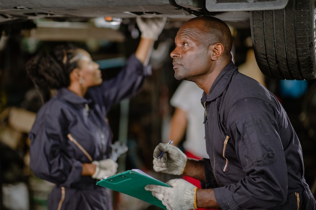 Garage monteur team werkende auto auto service zwarte Afrikaanse mensen professionele werker samen