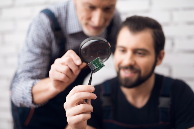 Garantiereparatie van microchiponderzoek met loep.