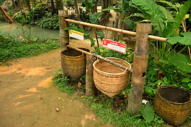 Garbage bamboo wicker basket lao style at bin area for laotian\
people and foreign travelers dropping waste wait cleaner keeping in\
kuang si falls or tat kuang si waterfalls at luang prabang\
laos