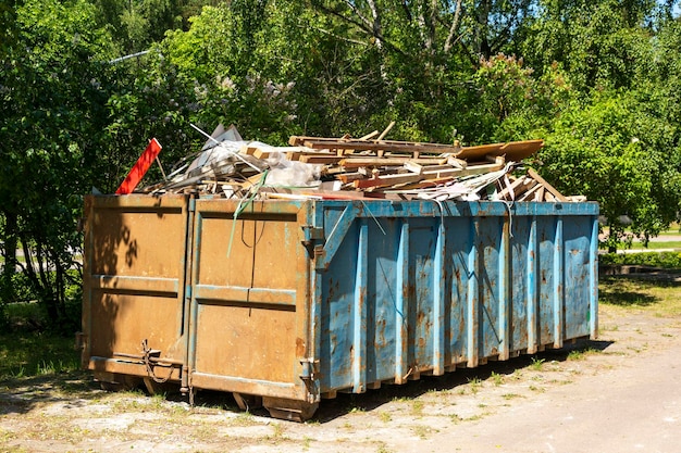 Garbage container equipped for transportation by truck filled with construction debris