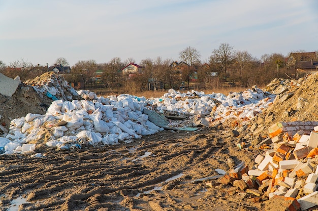 Мусорная свалка в городе на фоне домов Незаконная мусорная свалка в городе