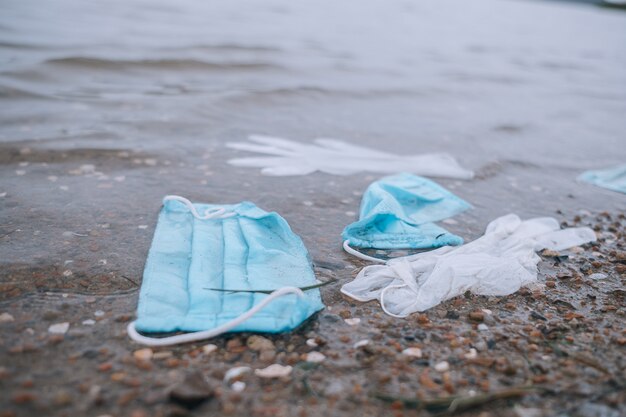 Garbage from used medical masks and gloves on the water