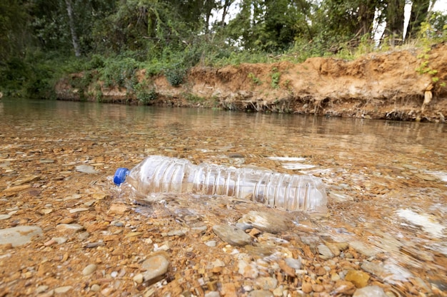 Foto spazzatura in natura una bottiglia di plastica gettata nel fiume