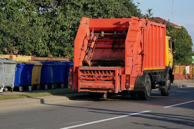 Foto camion della spazzatura vicino ai contenitori della spazzatura