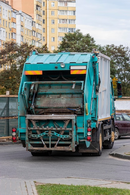 Photo a garbage truck picks up garbage in a residential area. separate collection and disposal of garbage. garbage collection vehicle.