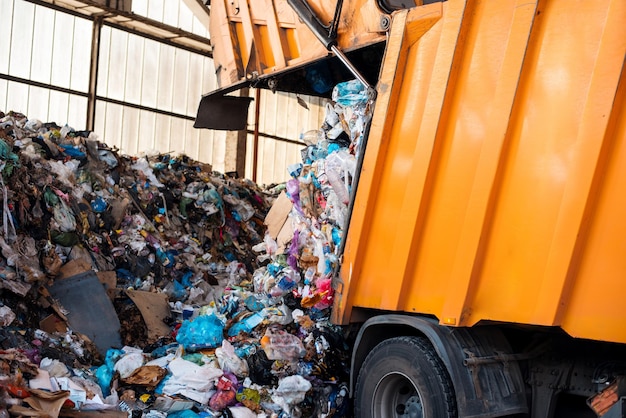 Foto un camion della spazzatura che lavora nell'impianto di smistamento dei rifiuti