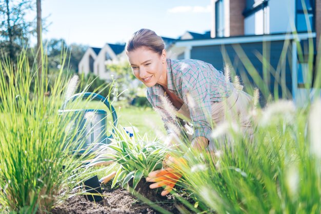 Garden bed. Loving family woman feeling happy and rested while relaxing on weekend while working in garden bed