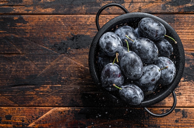 Garden blue plums in a colander.