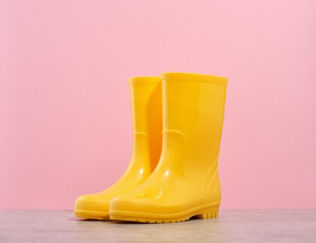 Photo garden concept bright yellow rubber boots on table