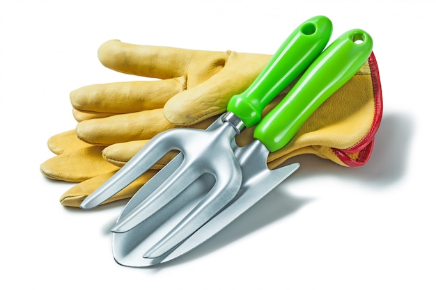 Garden fork and hand spade on gloves isolated