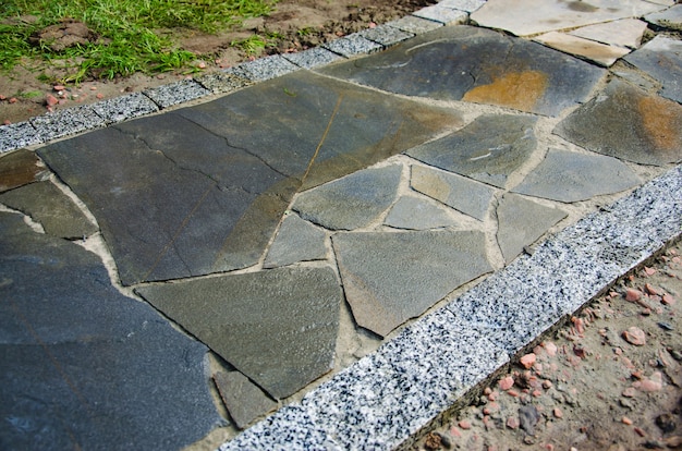 Garden path with natural stone slabs and edging made of paving stones