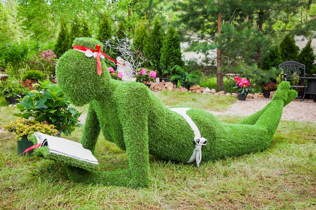 Garden Sculpture from grass woman with book on holiday in nursery Red maple Minsk Belarus