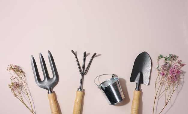 garden shovel and metal bucket on beige background top view