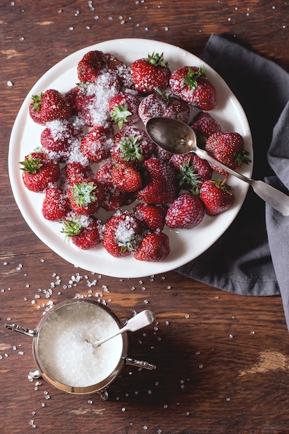 Garden strawberries with sugar and cream