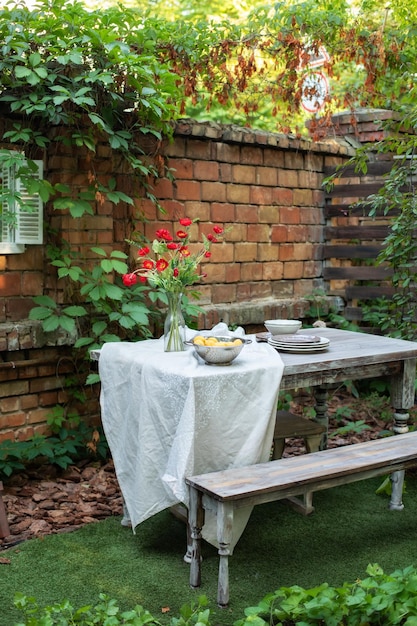 パティオ、木製の庭の家具、調理器具を備えた夏の庭。パティオまたはバルコニーの居心地の良い空間