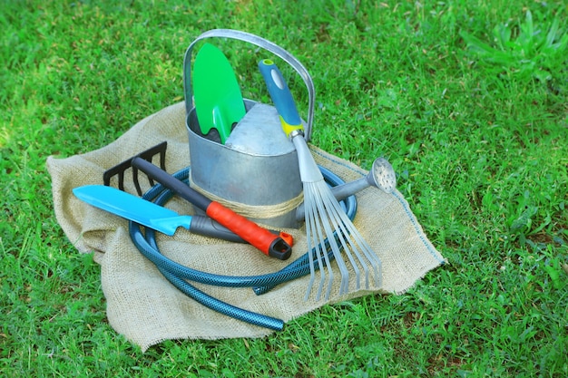 Garden tools on green grass background