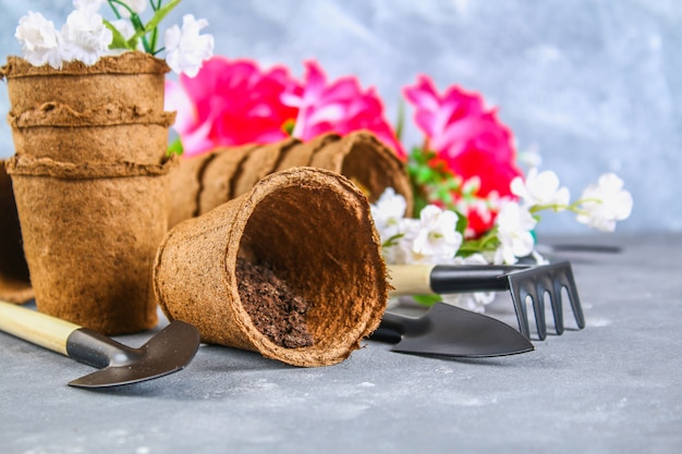 Garden tools, pots on a gray concrete background. Copy the space.