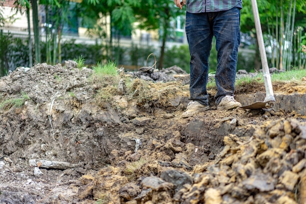 Gardener digs the soil with his equipment for gardening and prepare land for plantation.