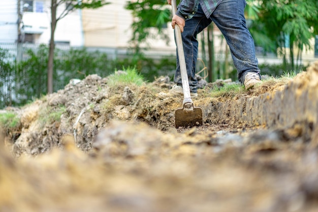 Gardener digs the soil with his equipment for gardening and\
prepare land for plantation