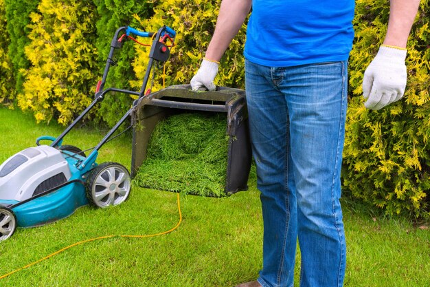 Gardener and a full container of mowed grass closeup