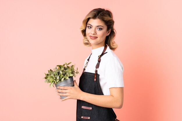 Foto ragazza del giardiniere che tiene una pianta