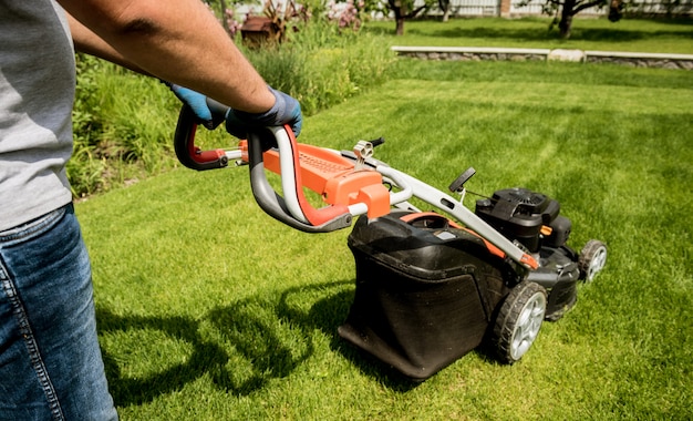 Gardener mowing the lawn. Landscape design.