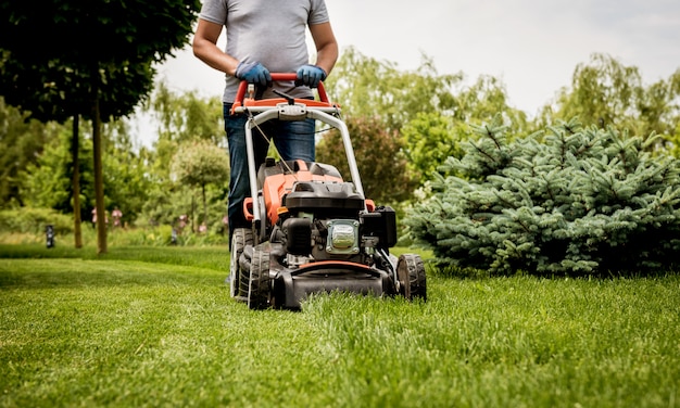 Gardener mowing the lawn. Landscape design.