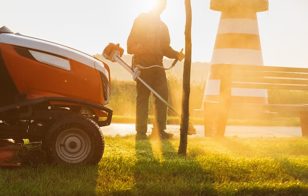 Gardener mows the lawn in the early morning at dawn. Lawn care.