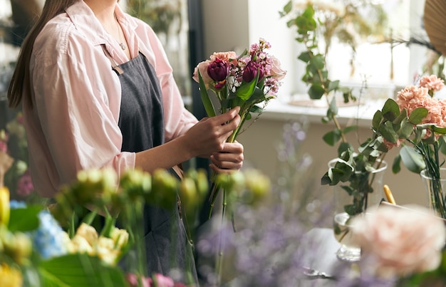 Il giardiniere nel negozio di fiori prepara il bouquet per una vacanza.