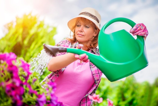 庭で彼女の植物の世話をしている庭師