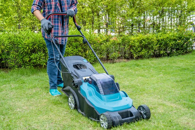 Gardener use lawn mover machine cut green grass Hobby planting home garden