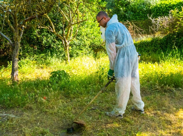 Gardener using brush cutter