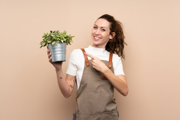 庭師の女性が植物を押しながらそれを指す