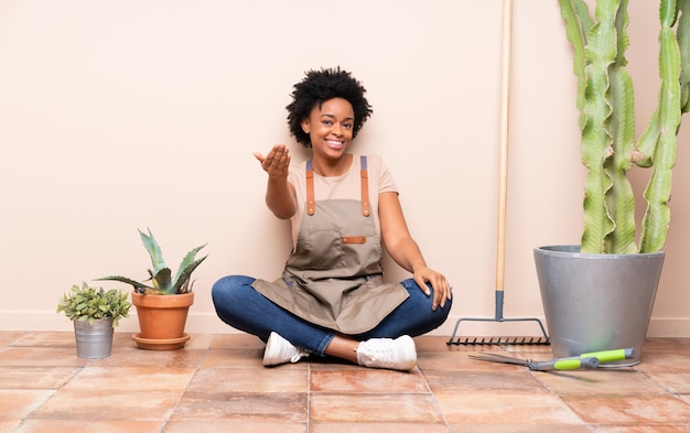 Gardener woman sitting on the floor around plants