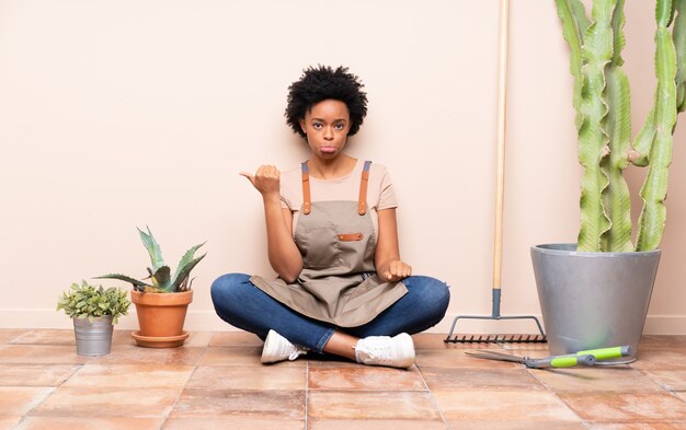 Gardener woman sitting on the floor around plants