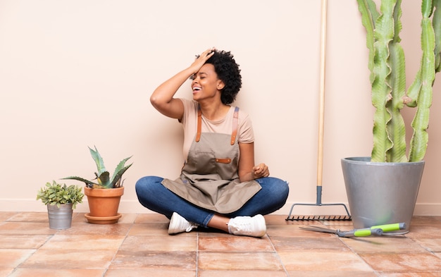 Gardener woman sitting on the floor among plants