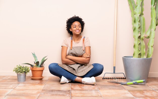 Gardener woman sitting on the floor among plants