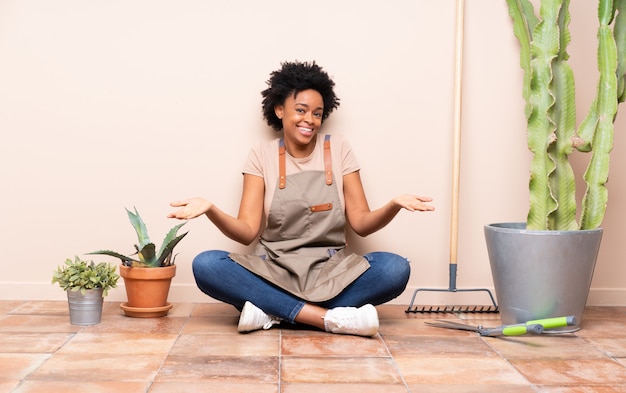 Gardener woman sitting on the floor among plants