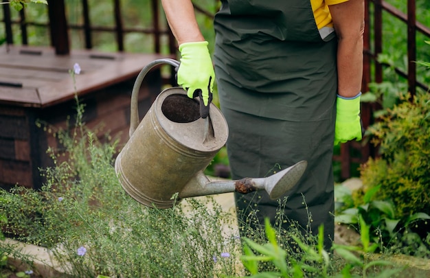 彼女の庭で働く庭師の女性花や植物の成長と世話をするガーデニングの概念