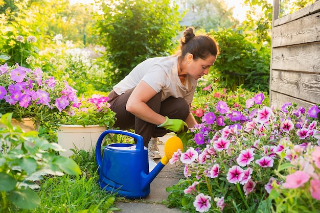 Gardening and agriculture concept young woman farm worker gardening flowers in garden gardener