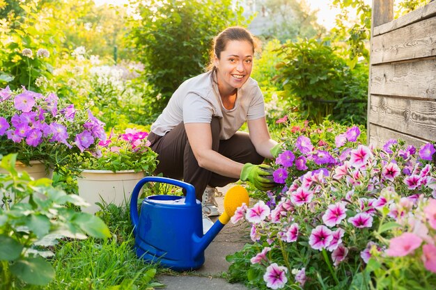 Gardening and agriculture concept young woman farm worker gardening flowers in garden gardener