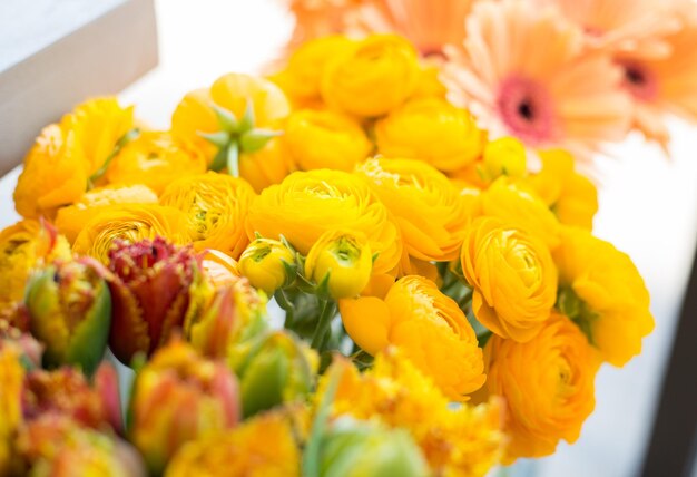 gardening, floristry, sale, holidays and flora concept - close up of beautiful yellow ranunculus flowers at flower shop