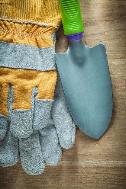 Gardening hand spade protective gloves on wooden board